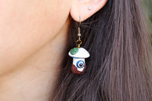 Load image into Gallery viewer, Model wearing White and Blue Mushroom Earrings with Evil Eye, Leaves, and Textured Dirt.
